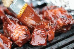 BBQ sauce being brushed onto ribs.