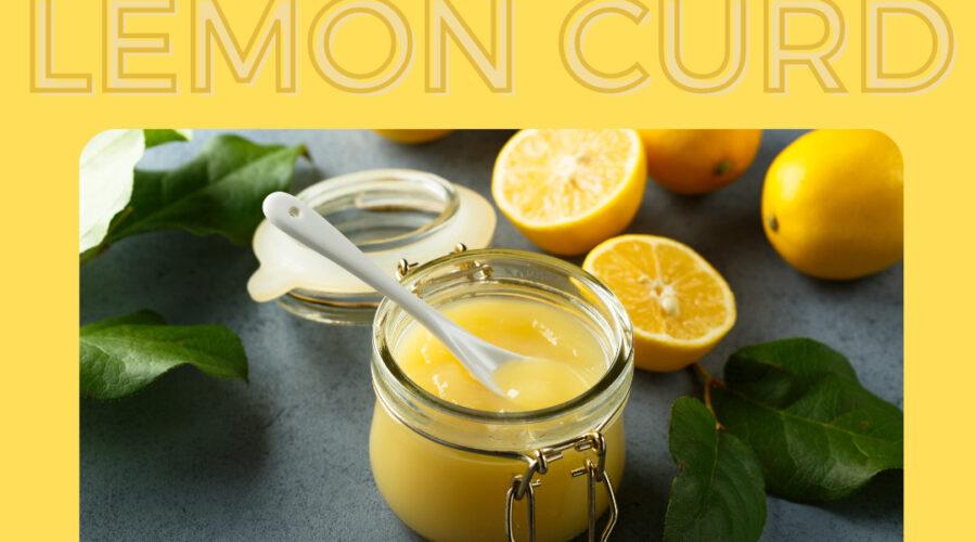 Photo of lemon curd in a glass jar with a spoon and cut lemons in the background