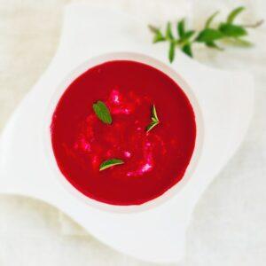 photo of ginger beet soup with thyme leaves sprinkled on top
