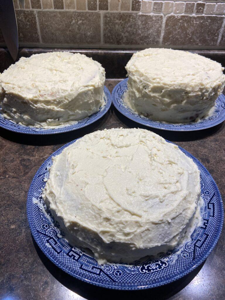 a photo of three homemade white chocolate celebration cakes on blue plates