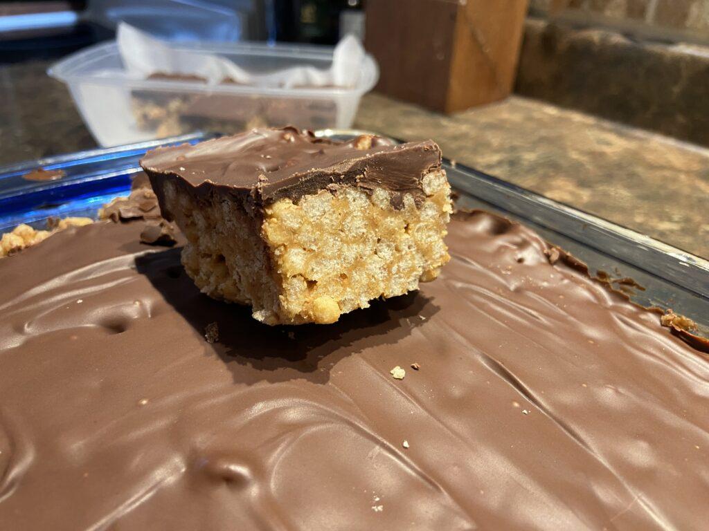 a piece of cannabis infused scotcheroos sitting on top of a full pan 