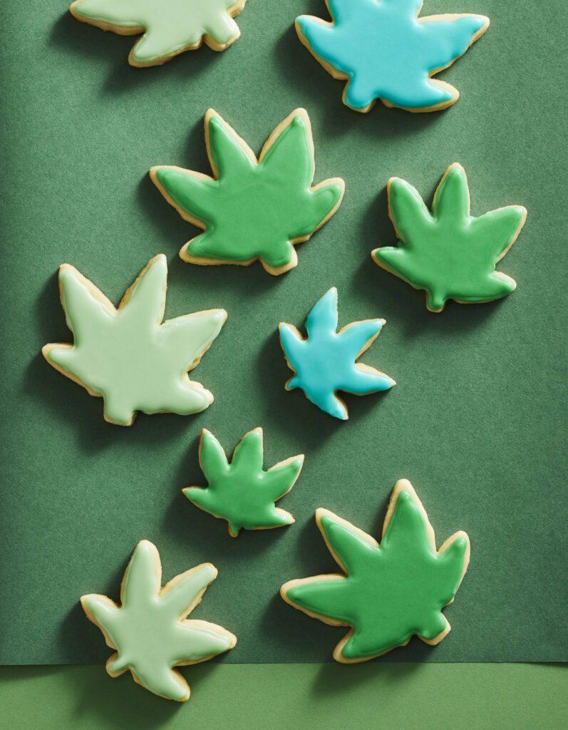 A group of shortbread cookies with green icing shaped in cannabis leaves from the book Butter and Flower by Ann Allchin.