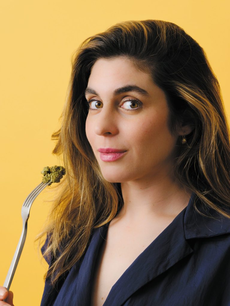 head and shoulder shot of vanessa lavorato holding a fork with a nug of cannabis on it, as if to eat it.