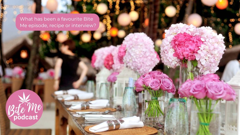 image of 4 table settings at a long table with vases of pink flowers at each seat for bite me podcast anniversary