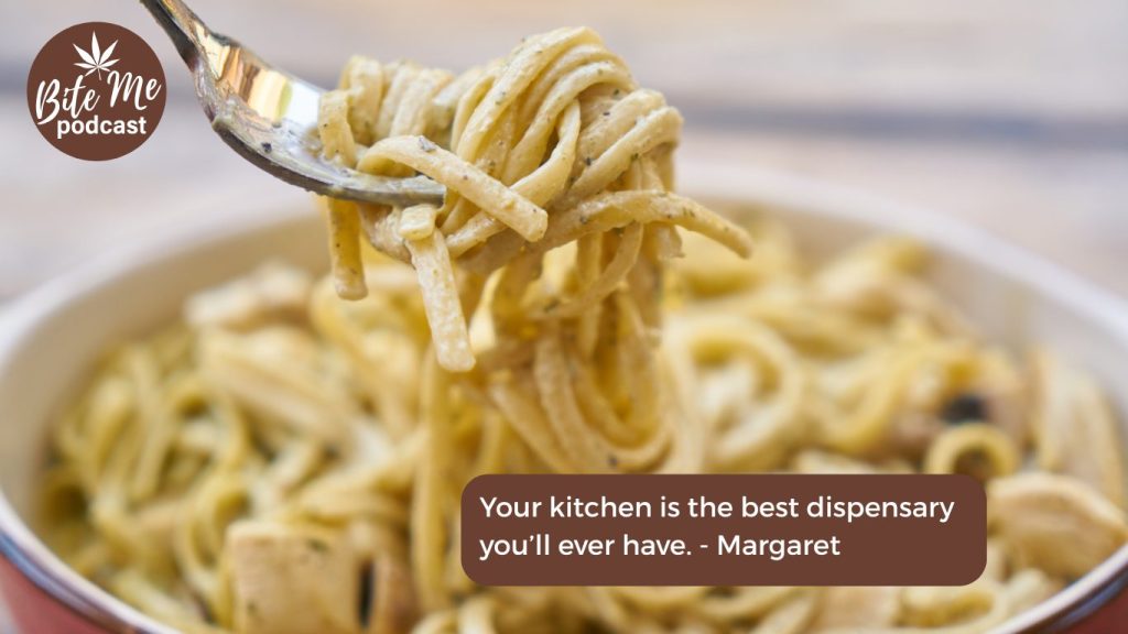 image of a fork with infused lemon zucchini pasta wrapped around the tongs with the bowl of pasta blurred in the background